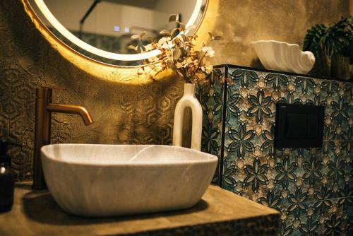 a bathroom with a bowl sink and a mirror at RAC by Zodiac Resort in Ceraşul