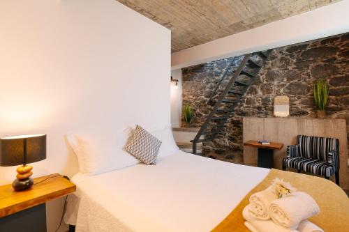 a bedroom with a bed and a chair at Casa do Sol by Amazing Madeira in Jardim do Mar