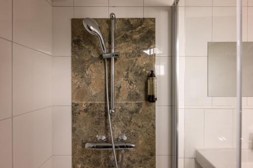 a shower with a glass door in a bathroom at Hotel INGREDI in Bree