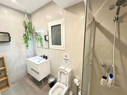 a bathroom with a toilet and a sink and a shower at Rooms Balmes in Barcelona