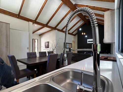 a kitchen sink with a faucet next to a table at Sand River Guest House in Johannesburg