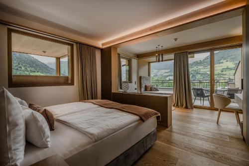 ein Schlafzimmer mit einem großen Bett und großen Fenstern in der Unterkunft Hotel Bismarck in Bad Hofgastein