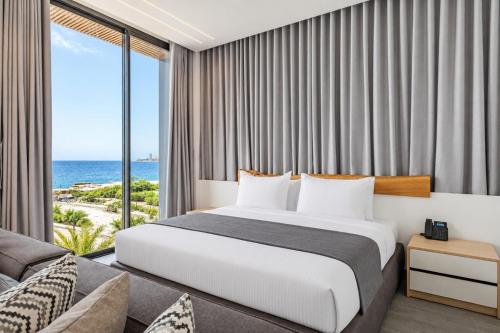 a bedroom with a bed and a view of the ocean at Middle Beach Hotel in Jounieh