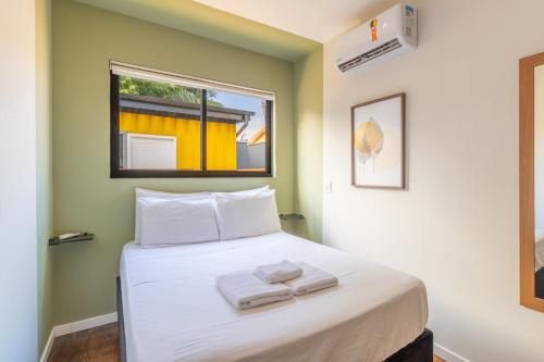 a bedroom with a bed with two towels on it at SPA-AC-BBQ-Casa Container-Cozinha Completa in Florianópolis