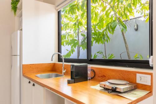 a kitchen counter with a sink and a window at SPA-AC-BBQ-Casa Container-Cozinha Completa in Florianópolis