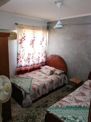 a bedroom with two beds and a window at Super star Chalet in Grand beach in Ras Sedr