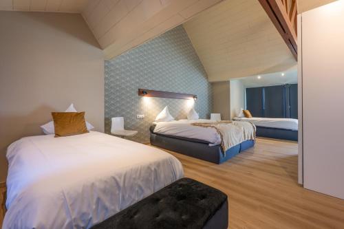 a hotel room with two beds and a window at Hotel INGREDI in Bree