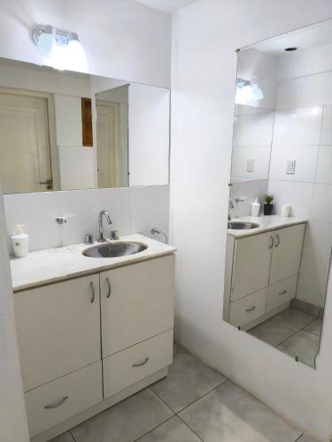 a bathroom with two sinks and a large mirror at Casa hasta 10 personas. in Villa Rumipal