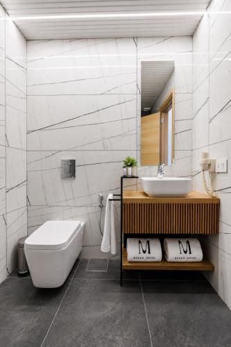 a bathroom with a sink and a toilet and a mirror at Middle Beach Hotel in Jounieh
