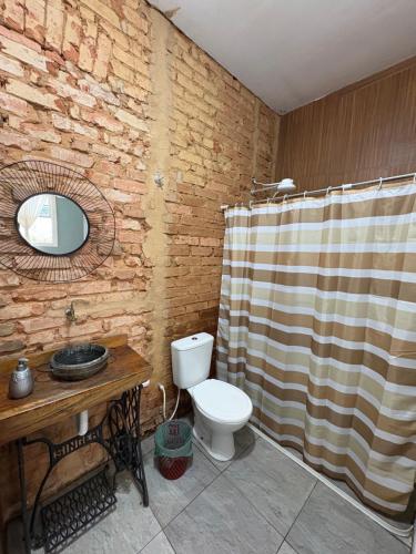 a bathroom with a toilet and a shower curtain at Villa Aruanda in Petrópolis