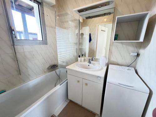 a small bathroom with a sink and a tub at Le Cocon Baulois in La Baule