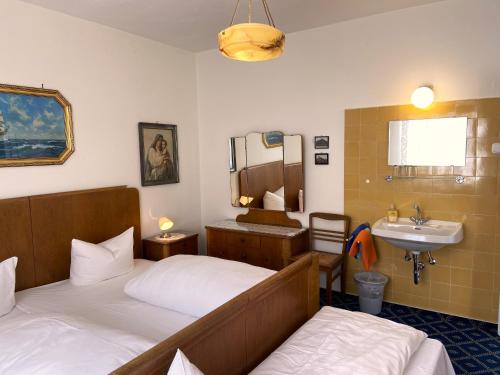 a hotel room with two beds and a sink at Hotel Krone in Gößweinstein