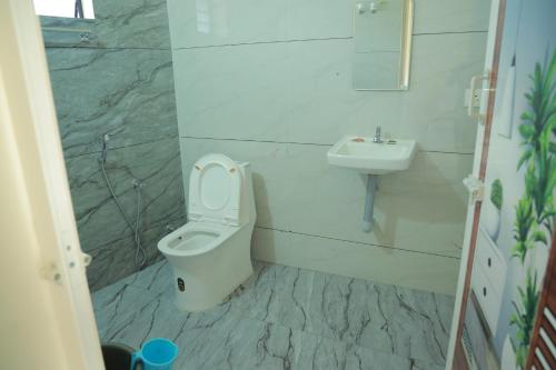 a bathroom with a toilet and a sink at Vetri Residency in Agastīswaram