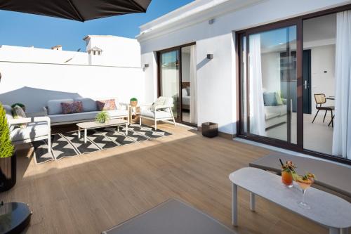 a living room with a couch and a table at AZUL HOME SUITES Estepona in Estepona
