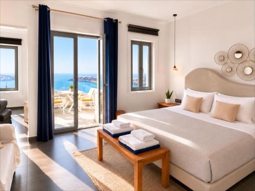 a bedroom with a bed and a view of the ocean at Esmi Suites Santorini in Imerovigli