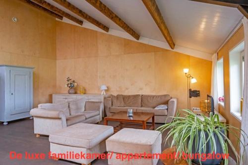 a living room with two couches and a table at opdehoekvandestal in Workum