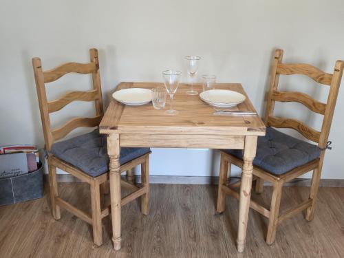 a wooden table and chairs with glasses and wine glasses at Ferienhaus Frida in Kleinich