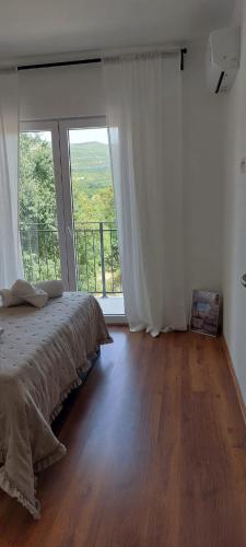 a bedroom with a bed and a large window at Apartman Ika 2 in Kruševo