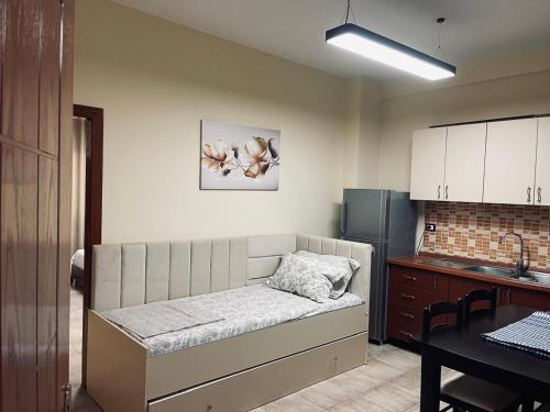 a room with a bed in a kitchen with a table at Shengjin Central Apartments in Shëngjin