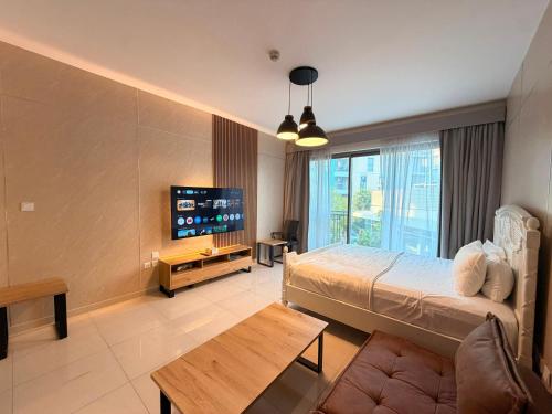a hotel room with a bed and a tv at Aesthetic Kings Studio at Uptown Al Zahia Sharjah in Sharjah
