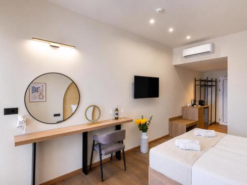 a bedroom with a mirror and a bed and a desk at Venezia Sea Side Suites in Faliraki