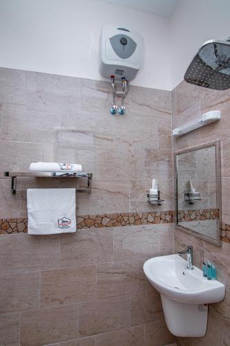 a bathroom with a sink and a mirror at Winsome Hotel Arusha in Themi