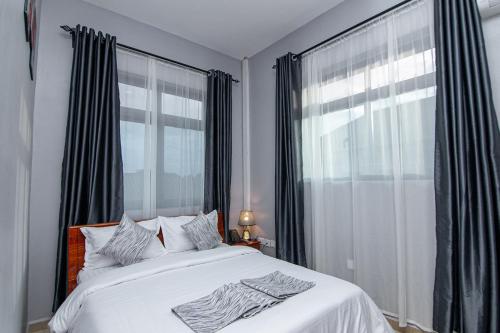 a bedroom with a bed and a large window at Winsome Hotel Arusha in Themi