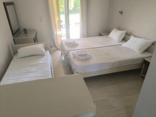 a room with two beds and a mirror at Alexandros and Georgia in Ipsos