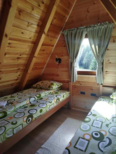 a bedroom with a bed in a log cabin at Durmitor Forest Retreat in Žabljak