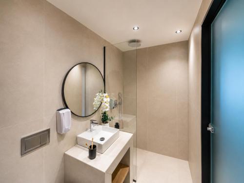 a bathroom with a sink and a mirror at Venezia Sea Side Suites in Faliraki
