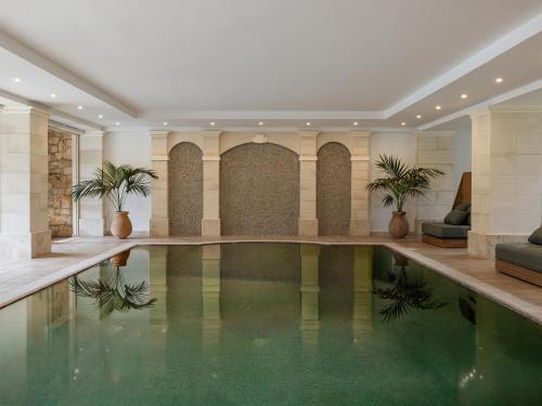 a swimming pool in a building with plants in it at Grecotel Casa Adele in Platanes