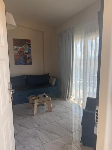 a living room with a blue couch and a table at Amphipolis Deluxe Apartments in Ofrínion
