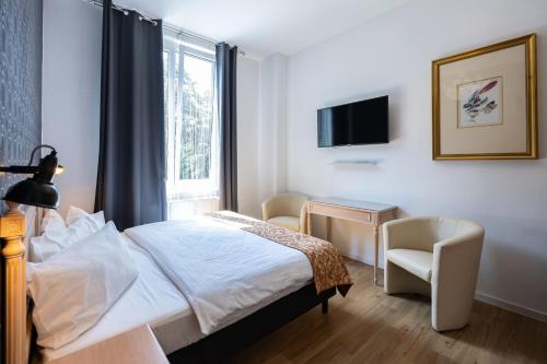 a hotel room with a bed and a window at Parkhotel Hohnstein by STEIGER Hotels in Hohnstein