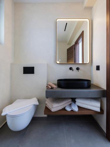 a bathroom with a sink and a toilet and a mirror at Villa Sabbia in Mesochórion