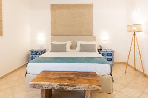 a bedroom with a large bed with a wooden table at CDSHotels Le Castella - Ninfe Saracene in Le Castella