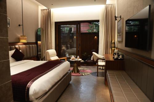 a hotel room with a bed and a living room at Kamah, Goa in Anjuna