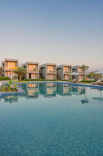 a large swimming pool in front of a resort at Vanam at Sasan in Sasan Gir