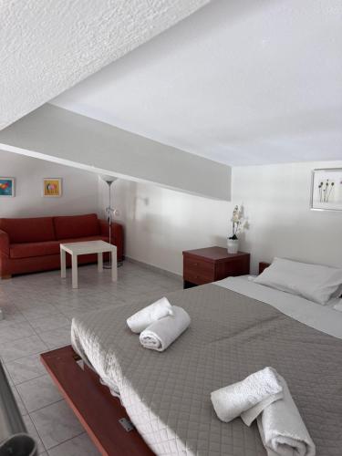 a bedroom with a bed and a red couch at Seaviewloft in Ofrínion