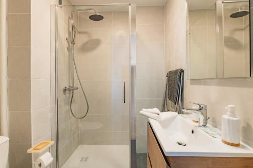 a bathroom with a shower and a sink at Le Traversant - Parking Gratuit in Bourg-lès-Valence