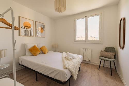 a bedroom with a bed and a chair and a window at Le Traversant - Parking Gratuit in Bourg-lès-Valence