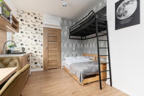 a bedroom with a bunk bed and a kitchen at ToTuLokum in Krakow