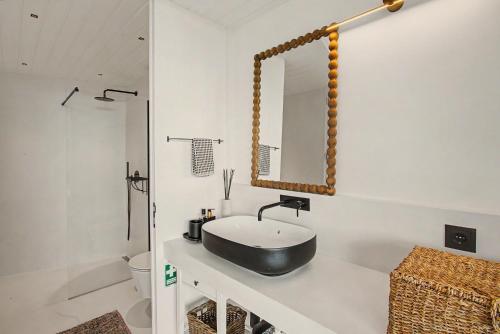 a bathroom with a black sink and a mirror at The Village Barn in Caniço