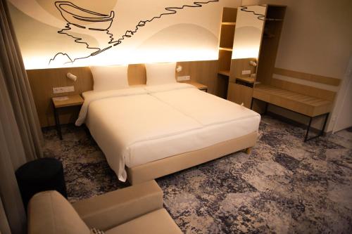 a hotel room with a bed and a couch at Arche Hotel Lotnisko Gdańsk in Gdańsk-Rębiechowo