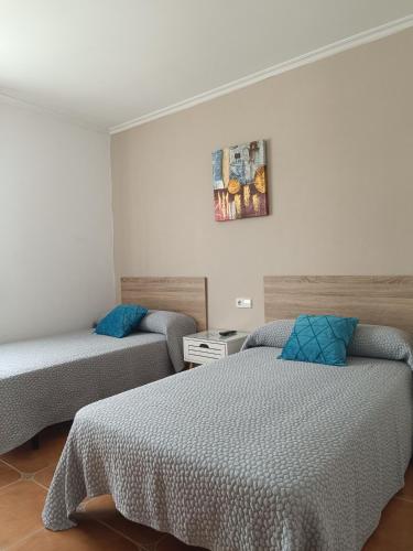 a bedroom with two beds and a picture on the wall at Casa Alonso in Narón
