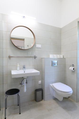 a bathroom with a sink and a toilet and a mirror at Norbi cölöpház in Tiszafüred