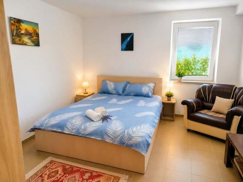a bedroom with a bed and a chair at Tetins'Apartmens in Trpejca
