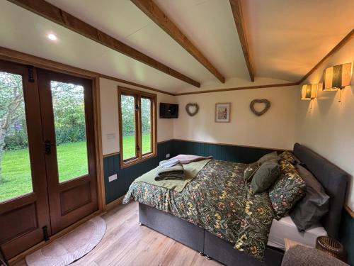 a bedroom with a bed in a room with windows at The Coach House or The Shepherd Hut in Blackpool