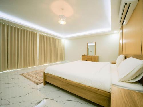 a bedroom with a large bed and a large window at Palm Escape Farmhouse - By Seven Elements in Ras al Khaimah