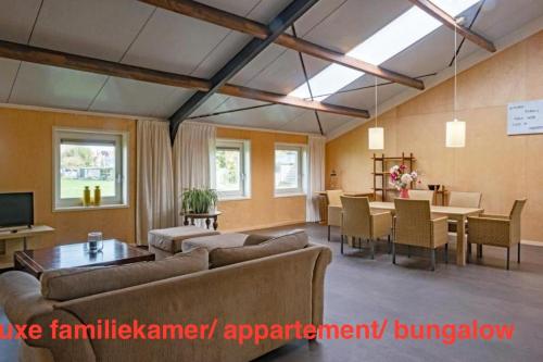 a living room with a couch and a table and chairs at opdehoekvandestal in Workum