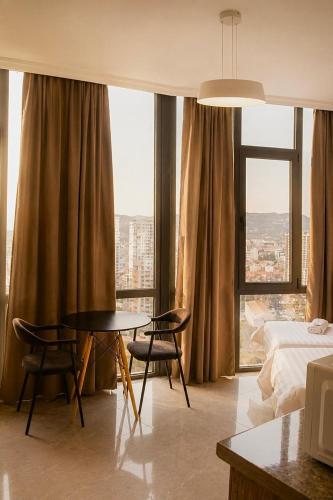 a hotel room with a bed and a table and chairs at VELOR Hotel apartment in Batumi